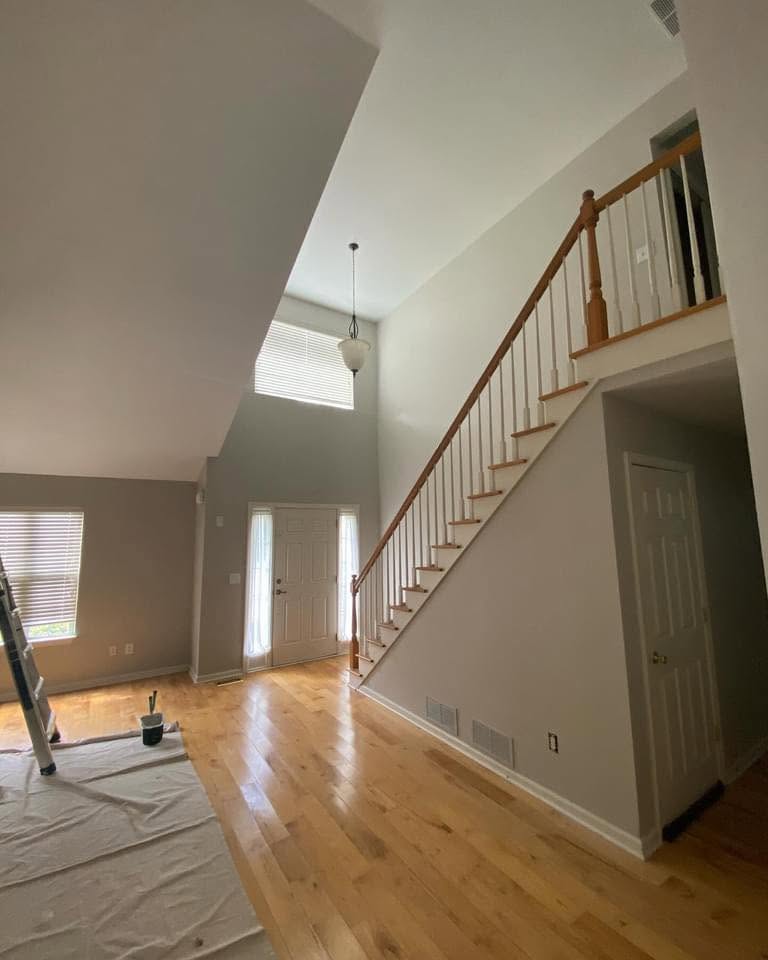 Two-story entryway and stairwell freshly painted in a soft neutral