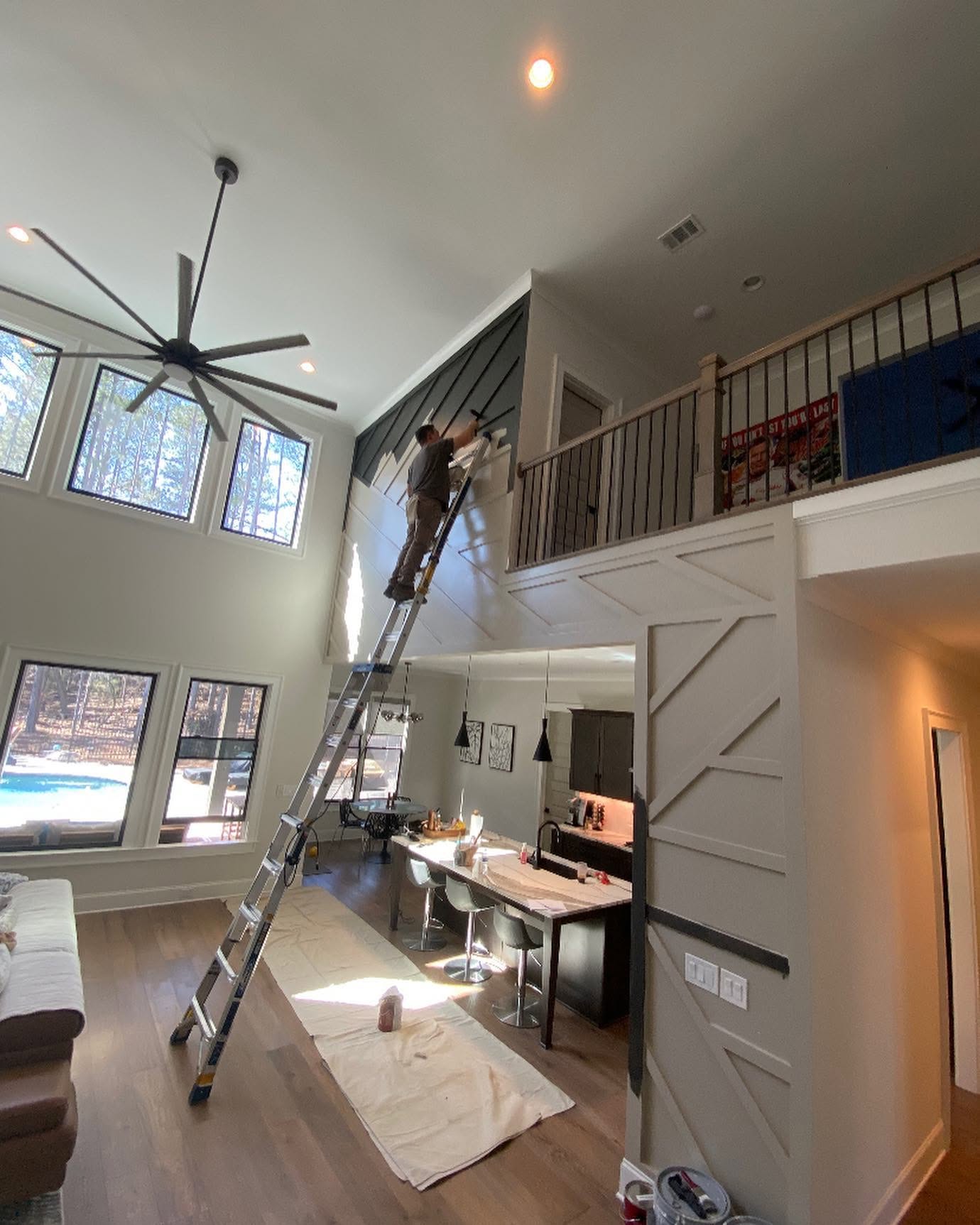 Stahl Precision painter finishing a custom accent wall on a tall ceiling