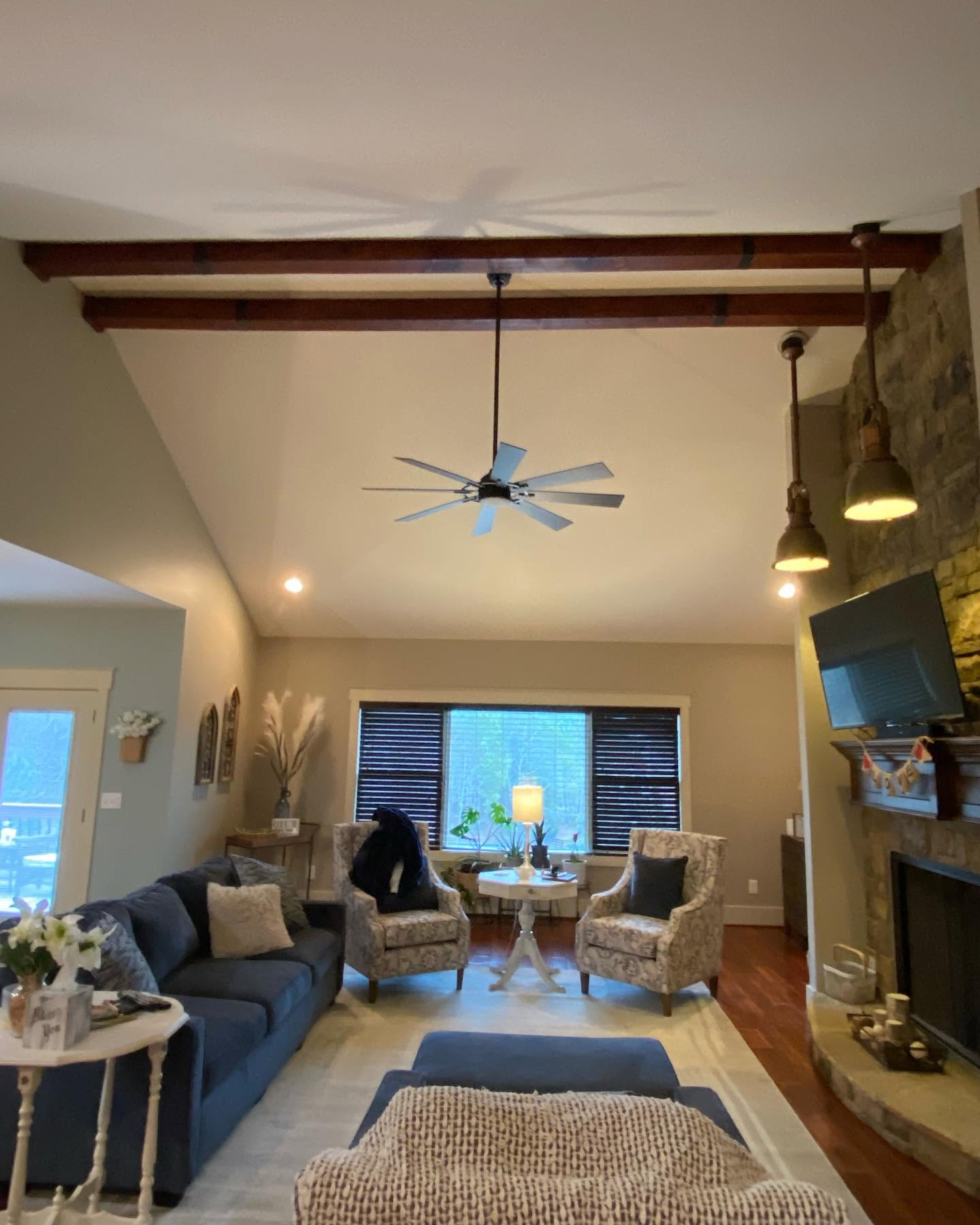 Living room with vaulted ceiling, exposed beams, and a clean repaint