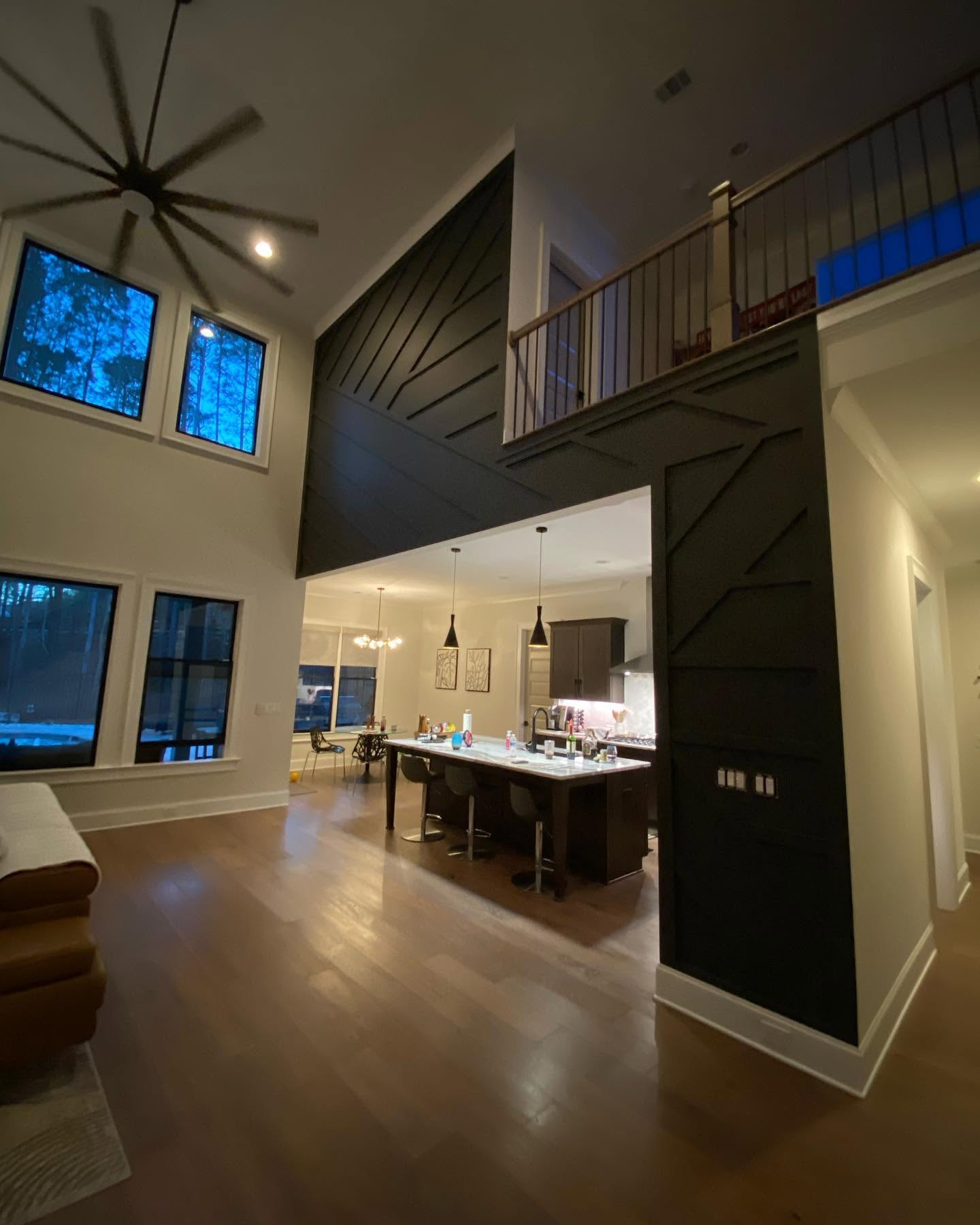 Dramatic dark green accent wall and high ceiling finish work